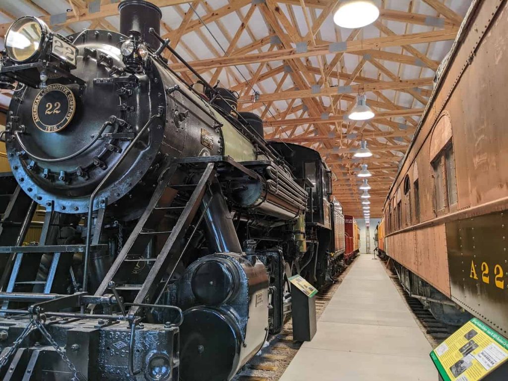 Image of Mid-Continent Railway Museum: A Living History of Railroading in the Midwest Located in North Freedom, Wisconsin, the Mid-Continent Railway Museum is an outdoor, living museum dedicated to preserving the rich history of railroading in the Midwest. The museum offers train rides and exhibits on historic trains and rail equipment, recreating the small town and short line way of life during the “Golden Age of Railroading.” What is Mid-Continent? The Mid-Continent Railway Historical Society, also known as the Mid-Continent Railway Museum, was established to recreate the era when the railroad station was the hub of social and communication activities in small towns. Operating since 1963 in North Freedom, the museum features operating trains, educational exhibits, and displays of restored rolling stock, offering visitors an immersive experience of railroading history. Vision and Mission Vision Statement: The Mid-Continent Railway Museum envisions itself as a place where visitors can learn about the historical significance of railroad stations in small communities. These stations were vital for transportation, information, and the shipment of goods, connecting towns to the broader world. Mission Statement: The museum’s mission is to educate the public by accurately recreating the Golden Years of Railroads, from the Civil War era to post-World War II, using vintage equipment. The museum aims to collect, preserve, restore, and operate artifacts from this period to provide visitors with a firsthand experience of historical railroading. Mid-Continent History Founded in 1959 as the Railway Historical Society of Milwaukee, the Mid-Continent Railway Museum began its mission to perpetuate the heritage of steam railroads through authentic operation and display. Initially based in Hillsboro, Wisconsin, the society moved to North Freedom in 1963 after purchasing 4.2 miles of track from the Chicago & North Western Railroad. This move allowed the society to offer steam train rides and expand its collection of historic rolling stock. Exhibits and Attractions The Mid-Continent Railway Museum boasts a vast collection of restored rail equipment, including steam and diesel locomotives, passenger cars, freight cars, and cabooses. The museum’s exhibits cover various aspects of railroading history, providing a comprehensive look at the development of rail transport in the upper Midwest. Train Rides: One of the main attractions is the train rides, which offer visitors a chance to experience rail travel as it was in the early 20th century. These rides are available throughout the operating season, providing a unique and nostalgic experience. Historic Displays: The museum features well-organized displays of railroad artifacts, including tools, uniforms, and communication equipment. These exhibits help illustrate the day-to-day operations and technological advancements in railroading. Educational Programs: The Mid-Continent Railway Museum offers educational programs and events, including guided tours, workshops, and special events like railfan weekends and themed train rides. These programs are designed to engage visitors of all ages and foster a deeper understanding of railroading history. Community and Volunteer Involvement The Mid-Continent Railway Museum operates as a non-profit, membership-driven organization. Its members, who come from various backgrounds and professions, play a crucial role in the museum’s operations and growth. Volunteers work as brakemen, locomotive engineers, steamfitters, carpenters, researchers, and more, contributing their time and skills to preserve and promote the museum’s mission. Membership Benefits: Membership in the Mid-Continent Railway Historical Society offers several benefits, including publications, discounts at the museum store, and free train rides. More importantly, members support the preservation and educational efforts of the museum, helping to maintain one of the most authentic railroading institutions in the country. Future Plans Looking ahead, the Mid-Continent Railway Museum plans to continue its efforts to preserve and interpret the history of Midwest railroading. The museum aims to expand its collection, enhance its exhibits, and develop new educational programs to reach a broader audience. With over 500 members from 38 states and the United Kingdom, the museum is well-positioned to carry forward its mission of historical preservation and education. Visiting Information The Mid-Continent Railway Museum is located in North Freedom, Wisconsin, near popular tourist destinations like Baraboo and the Wisconsin Dells. The museum is open to the public during the warmer months, with specific hours and train schedules available on their website. Contact Information: For more information or to plan your visit, contact the Mid-Continent Railway Museum at 608-522-4261 or visit their website at www.midcontinent.org. Conclusion The Mid-Continent Railway Museum in North Freedom, Wisconsin, is a living history museum that offers a fascinating glimpse into the Golden Age of Railroading. Through its collection of historic trains, engaging exhibits, and educational programs, the museum provides an enriching experience for visitors of all ages. Whether you are a rail enthusiast, a history buff, or simply looking for a unique outing, the Mid-Continent Railway Museum offers a memorable journey into the past. For additional details and membership information, visit the museum’s official website and join the community dedicated to preserving the legacy of Midwest railroading.